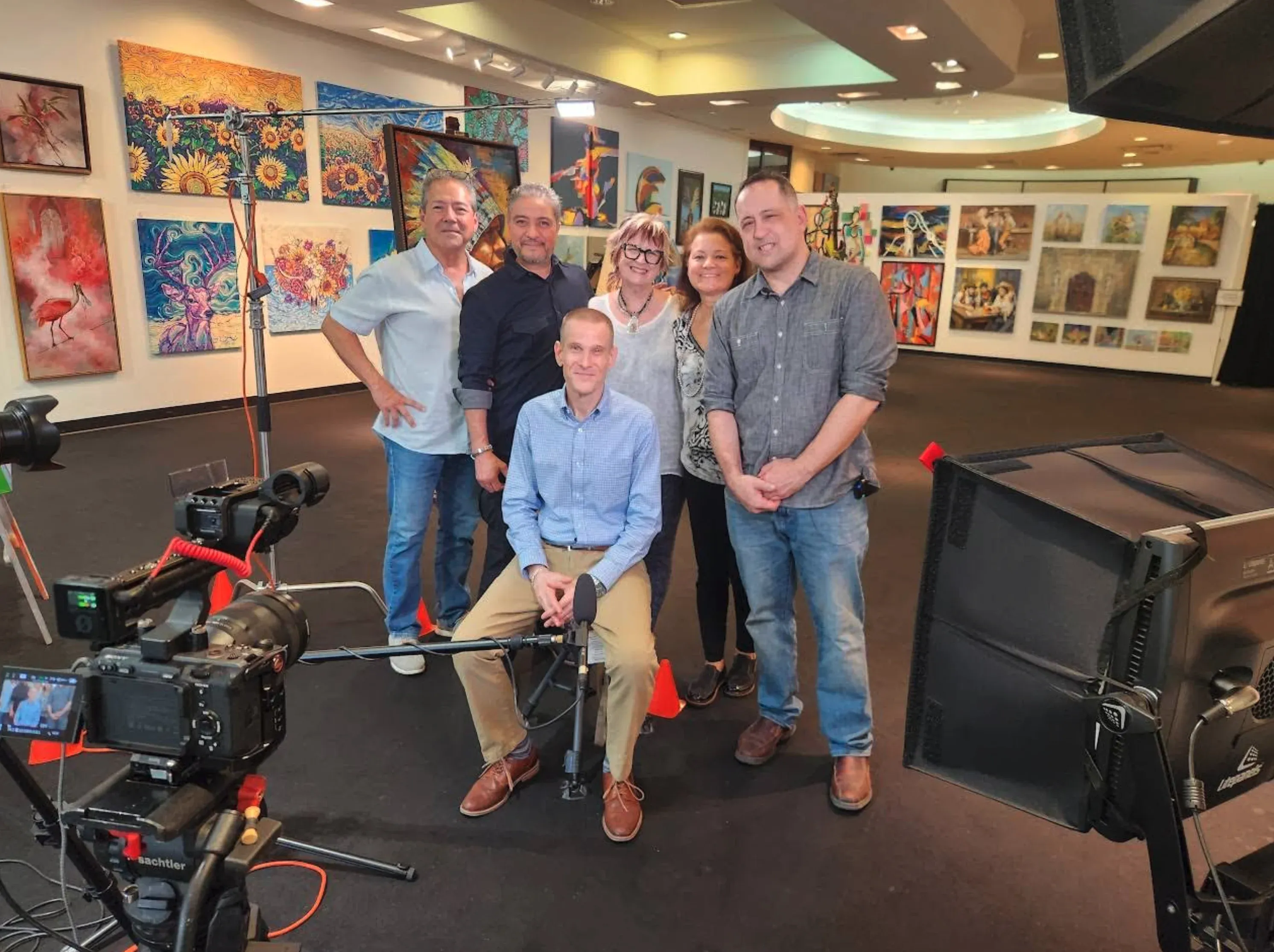 Doriva team during a professional video shoot inside the gallery surrounded by original artwork from local San Antonio artists